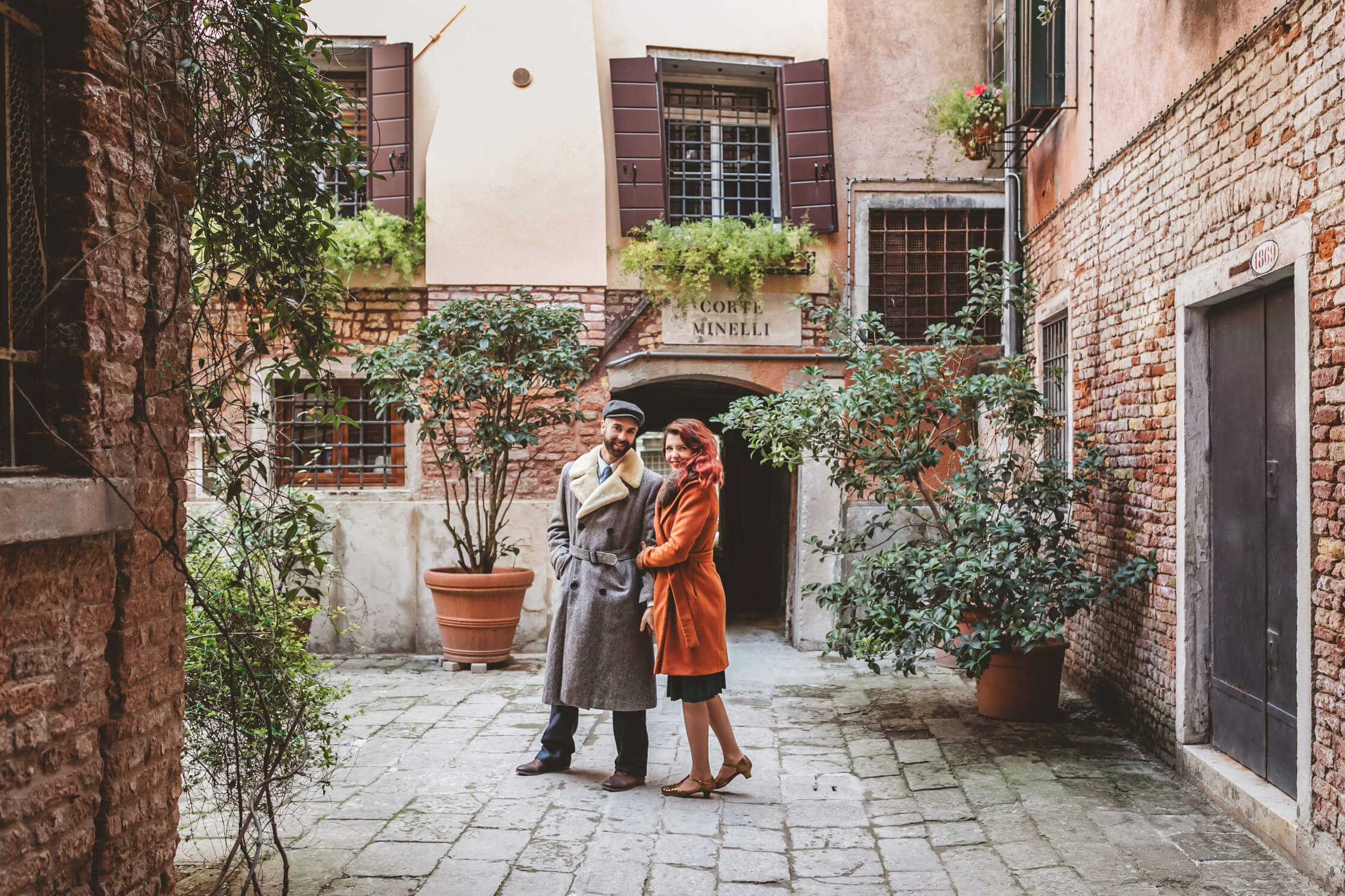 The couple is looking at the photographer during the photoshoot in Venice.